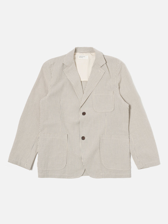 Two Button Jacket Grey Derby Stripe Universal Works, veste élégante et minimaliste avec une coupe ajustée. Tissu texturé à fines rayures grises pour un look intemporel et raffiné. Fermeture à deux boutons pour une allure moderne et structurée. Disponible exclusivement en boutique chez SEE YOU, concept store à Versailles.
