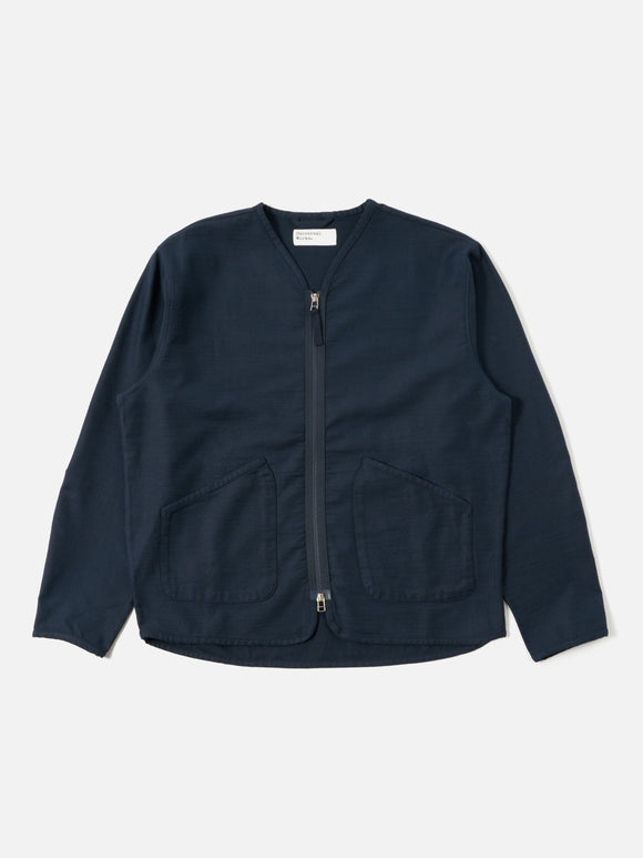 Zip Liner Jacket Navy Slub Sateen Universal Works, une veste légère et polyvalente avec une coupe décontractée. Confectionnée en satin de coton slub texturé, elle allie confort et élégance. Fermeture zippée bidirectionnelle et poches plaquées pour un style utilitaire moderne. Disponible en boutique chez SEE YOU, concept store à Versailles.